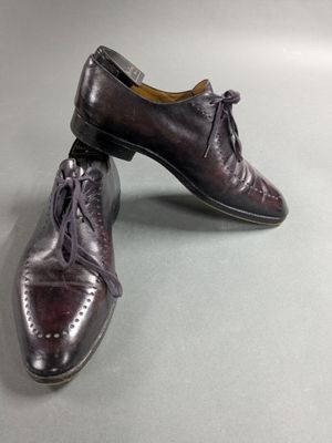pair of men ' s leather shoes with laces on them on a gray surface