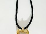 collier noir et doré avec un pendentif en forme de cœur doré sur un cordon noir