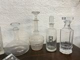 many different glass bottles on a table with a white wall in the background