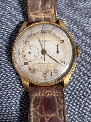 un gros plan d'une montre-bracelet posée sur un tissu bleu