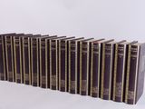six books are lined up in a row on a white surface
