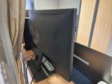 un écran d'ordinateur posé sur un bureau en bois