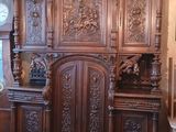 une grande armoire en bois dans une pièce où se trouve une horloge accrochée au mur