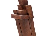 sculpture en bois représentant un homme tenant une pile de cubes sur fond blanc
