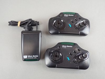 two remote controls and a charger sitting on a table