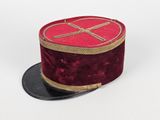 un chapeau haut-de-forme rouge orné d'un ruban doré sur fond blanc