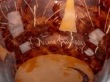 a brown vase with writing on it sitting on a table