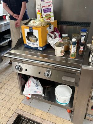a man standing in the kitchen preparing food on the stove