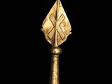 a close up of a gold object on a black surface