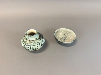 un petit vase et un petit bol posés sur une table