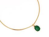 a gold necklace with a green stone on a chain