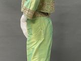 a mannequin wearing a green dress with gold trim