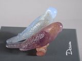 three glass birds sitting on top of a black box