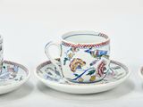 three cups and saucers are sitting side by side on a white surface