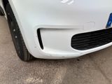 the front end of a white car with a denting bumper