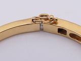 an image of a close up of a gold bracelet on a white surface