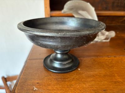 un saladier en métal posé sur une table en bois