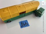 un petit bus en plastique posé à côté d'un autocollant bleu et jaune