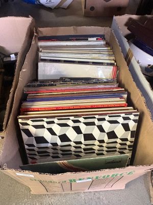 une boîte remplie de disques vinyles posée par terre