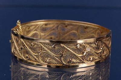 bracelet en or au motif raffiné sur une surface brillante