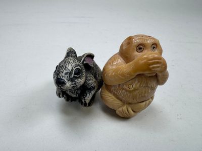 deux figurines de singes assis l'un à côté de l'autre