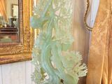 a statue of a dragon on a table in front of a mirror