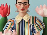 une femme en robe colorée, assise devant un cactus en fleurs