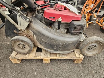 une tondeuse à gazon posée sur une palette dans le parking