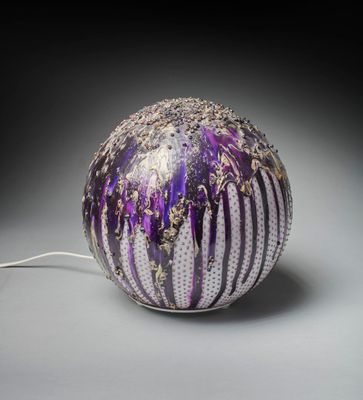 un vase violet et blanc auquel est attaché un cordon blanc