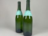 two bottles of wine sitting on top of a table next to each other