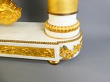 a white and gold table with a candle on it