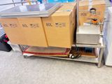 des cartons sont empilés sur un chariot dans un magasin