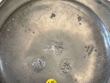 a silver plate with a yellow sticker on it