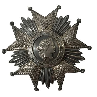 l'image d'une médaille en forme d'étoile avec le visage d'une femme au centre
