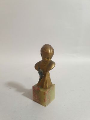 statue en bronze représentant un garçon armé d'un fusil, posée sur un bloc de marbre
