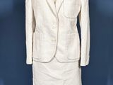 a white dress and jacket on a mannequin stand