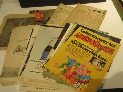 beaucoup de vieux livres posés sur une table, éclairés par une lampe
