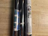 three baseball bats sitting on a table next to each other