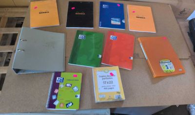 de nombreux cahiers de différentes couleurs posés les uns à côté des autres sur une table