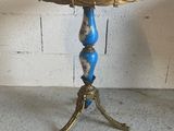 a small table with a blue top on a cement floor
