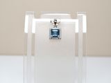 un collier orné d'une pierre bleue, exposé dans une vitrine