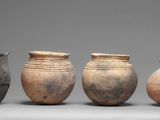 several vases are lined up in a row on a gray surface