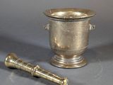 a small silver cup and a small brass object