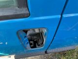 a person standing next to a blue truck with the door open