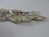 several cups and saucers are lined up on a white surface