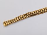 a close up of a gold chain bracelet on a white surface