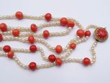 an image of a red and white beaded necklace with a gold clasp