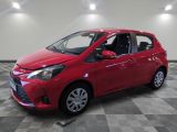 une Toyota Yaris rouge garée sur un sol à damier