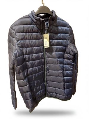 La veste est suspendue à un cintre sur un fond blanc