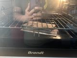 a person taking a piece of food out of a toaster oven